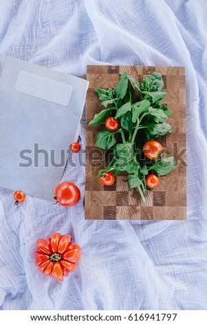 endgrain cutting board with tomatoes and spinach on blue textile background