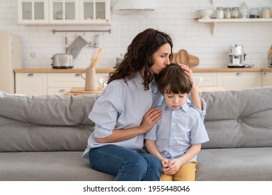 Ending of family fight: mother feel guilty and embrace disobedient son after scolding for misbehavior. Caring mom cuddling upset ashamed with misconduct son. Loving parent comfort unhappy kid with hug
