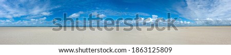 endless empty panoramic northsea beach background with wide sands an blue cloudy sky in the north of the island Fano in Denmark