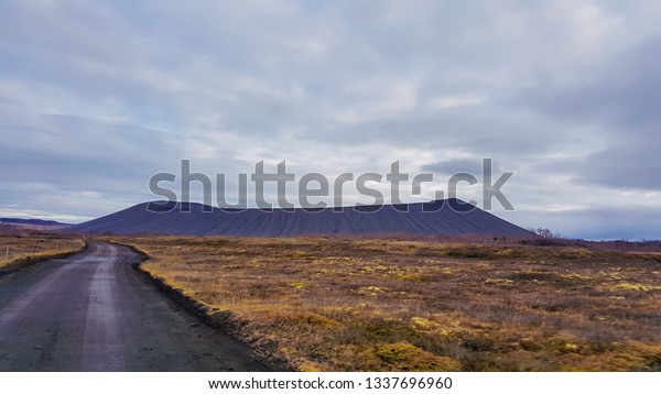 An\
endless road leading to the mountain side. Colors of autumn. Road\
is empty, no car passing by. Grass on the sides of the road is\
golden. Wilderness and loneliness. Road less\
traveled.