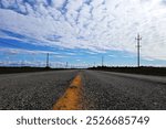 An endless road stretching under a bright blue sky