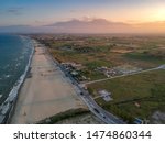 The endless sandy beach over seaside town Paralia Katerini - Aerial panorama over the Olympic Coast in Pieria, Central Macedonia, Greece at sunset.