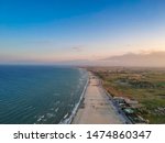 The endless sandy beach over seaside town Paralia Katerini - Aerial panorama over the Olympic Coast in Pieria, Central Macedonia, Greece at sunset.