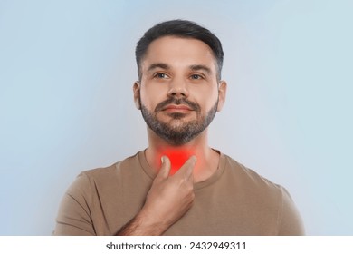Endocrine system. Man doing thyroid self examination on light grey background