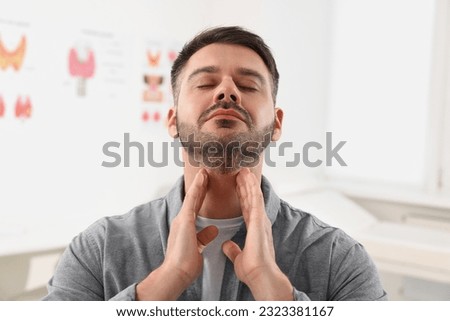 Endocrine system. Man doing thyroid self examination indoors