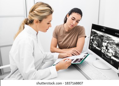 Endocrinologist Consulting The Woman, Doctor Analyzes The Ultrasound Of The Patient's Thyroid Gland. Treatment Of Thyrotoxicosis, And Hypothyroidism