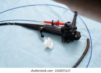 Endoscope, mouthpiece and biopsy forceps. Apparatus for gastroscopy, bronchoscopy, colonoscopy close-up. Tools for medical diagnostics close-up. Gastrointestinal endoscopy in the operating room.
