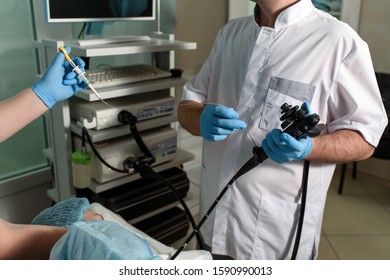 Endoscopic Examination In A Modern Clinic. The Doctor Holds An Endoscope In His Hand, The Nurse Holds The Forceps For A Biopsy Of The Patient. Medical Manipulations And Examination.