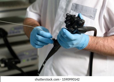 Endoscopic examination in a modern clinic. The doctor holds in his hand an endoscope and a wire loop before a colonoscopy.