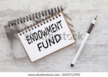 ENDOWMENT FUND . text on a notepad on a wooden background. white pen