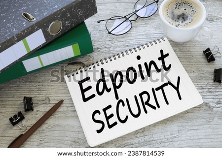 Endpoint Security a cup of coffee. glasses. two office folder gray notepad. text on the page