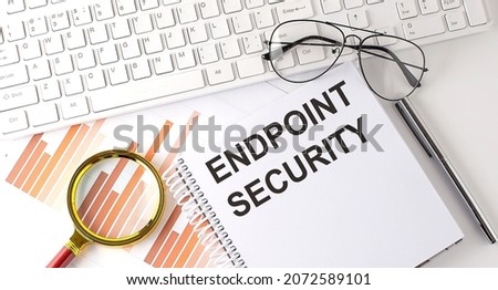 ENDPOINT SECURITY text written on the notebook with keyboard, chart,and glasses