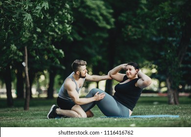 Endurance Training, Sport, Weight Loss, Teamwork And Healthy Lifestyle Concept. Plus Size Woman Working Out With Personal Trainer. Fitness Instructor Support, Abdominal Crunches, Fat Burning Exercises