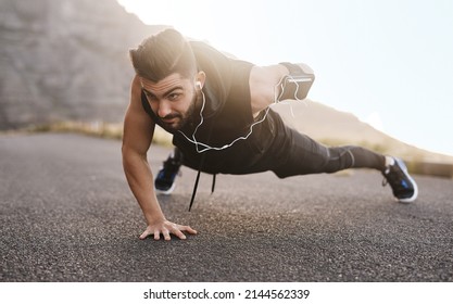 Endure every challenge and it will change you. Shot of a sporty young man doing pushups while exercising outdoors.