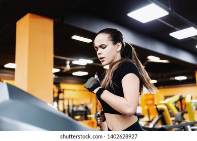 Enduring Serious Young Girl Triathlete Runs On A Treadmill After Strength Training In The Gym. Concept Of Skinny And Fat Burning