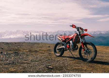 Enduro motocross Motorcycle on mountain top, off road, snow mountains peaks on background