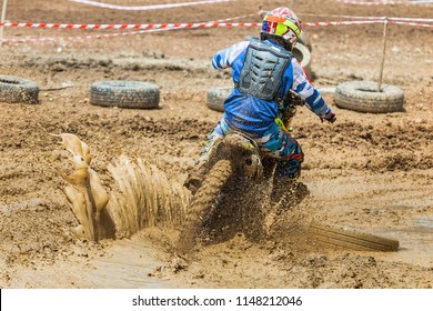 Enduro Rides Through The Mud With Big Splash,driver Splashing Mud On Wet And Muddy Terrain,Motocross Racer In A Wet And Muddy Terrain Covering The Driver Completely.