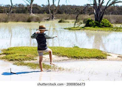 Eneabba Western Australia - August 26, 2018: Young Boy Splashing In The Water Of Lake Logue, A Shallow Seasonal Wetlands Area Which Rarely Contains Water. Outback Australia Travel Adventures.