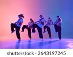 An energetic dance crew performs a synchronized routine under colorful stage lighting. Concept of teamwork and artistic expression in performing arts.