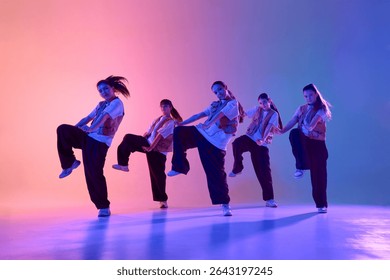 An energetic dance crew performs a synchronized routine under colorful stage lighting. Concept of teamwork and artistic expression in performing arts.