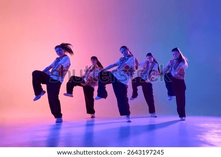 An energetic dance crew performs a synchronized routine under colorful stage lighting. Concept of teamwork and artistic expression in performing arts.