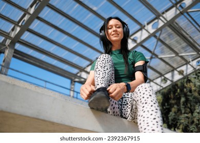 Energetic Female Athlete Tying Sneakers on Track - Powered by Shutterstock