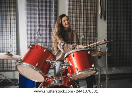 Energetic Female Drummer Enjoys Playing Red Drum Kit in a Casual Setting