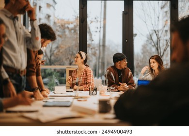 Energetic group of diverse people engaged in discussion at a bright, contemporary office. Collaboration and team dynamics in focus. - Powered by Shutterstock