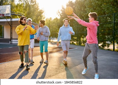 energetic, healthy teens have fun, talk before playing basketball, group of happy teenage boys in colourful casual wear, playing basketball outdoors in the city, go at playground - Powered by Shutterstock