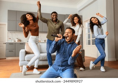 Energetic karaoke performance with a passionate singer and multiracial friends dancing and enjoying at home - Powered by Shutterstock