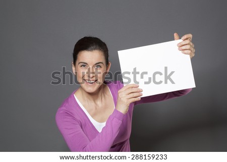 energetic smiling young woman raising a blank communication board with great news on