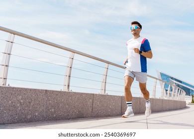 Energetic Young Man Jogging Along a Modern Waterfront Promenade on a Sunny Day - Powered by Shutterstock