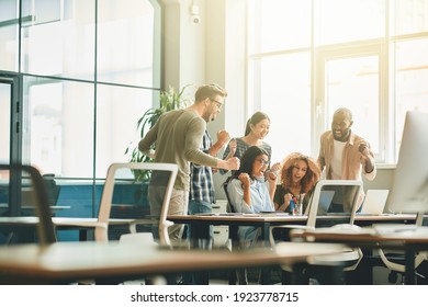 Energetic young people celebrating success of their project at work - Powered by Shutterstock