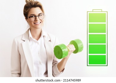 Energized Business Woman Lifting Green Dumbbell. Fully Charged Battery Symbol Beside. Concepts Of Active Life, Stress Free Work And Uplifting.