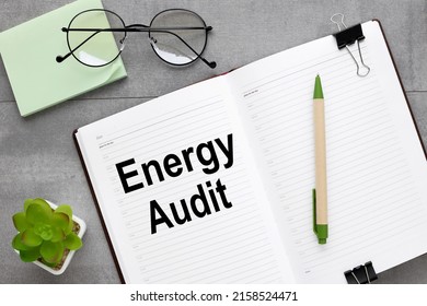 energy audit the inscription on an open diary, on a gray background a plant in a pot - Shutterstock ID 2158524471