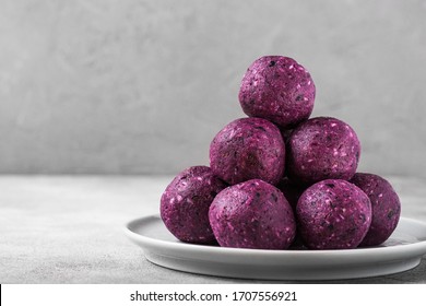 Energy balls or energy bites made of blueberries, acai, dates and nuts. Healthy vegan diet snacks. close up with copy space