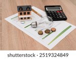 Energy Costs Concept with Light Bulb, Miniature House, Calculator and Coins on Electricity Bill, energy savings or home investment concept