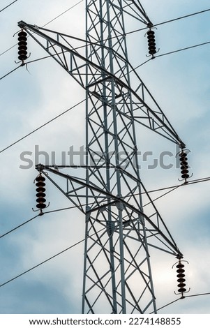 Energy crisis concept, electricity pylon with overhead powerline cables against dramatic overcast sky, selective focus