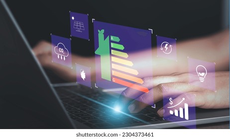 Energy efficiency rating and eco green home concept. Hand use laptop computer with house icon energy efficiency. Ecology house with low consumption on renovation with insulation. Show save cost icon. - Powered by Shutterstock