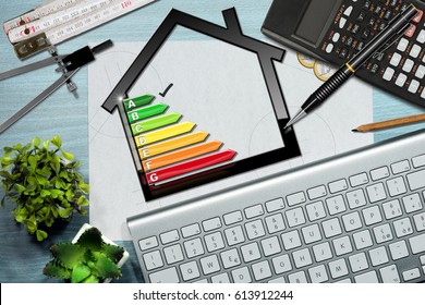 Energy efficiency rating graph on a desk with a house model, calculator, folding ruler, drawing compass, pencils and a computer keyboard - Shutterstock ID 613912244