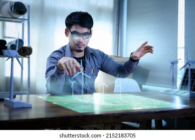 Energy Engineer Wearing AR Headset Or Hologram Glasses Future, Prototype Design Of Wind Turbine Farm With Map On Holographic Projection, Futuristic Design With Technology Application Basic.