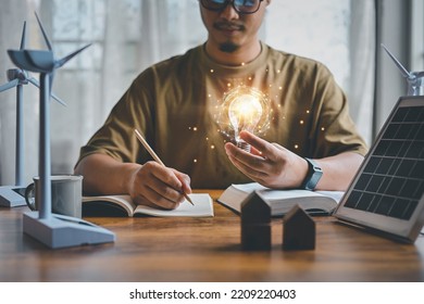 Energy engineers people holding light bulbs while thinking. Innovative concept, thinking of natural energy engineering in design, Knowledge in education, inspiration and imagination in technology. - Shutterstock ID 2209220403