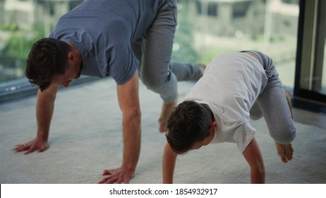 Energy Father And Child Doing Core Exercises At Home. Athletic Man And Boy Training Together In Big Window Interior. Sporty Dad And Son Having Workout Indoors.