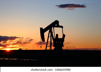 Energy industry oil pump silhouette with the sun setting with clear sky in the high plains of Texas