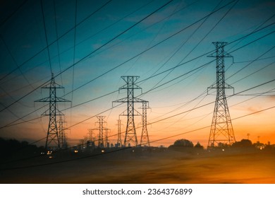 The energy power lines against a backdrop of a beautiful orange and yellow sunset sky - Powered by Shutterstock