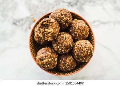 Energy Protein Balls With Healthy Ingredients On Marble Table. Home Made With Dates, Peanut Butter, Flax And Chia Seeds, Oats, Almond And Chocolate Drops