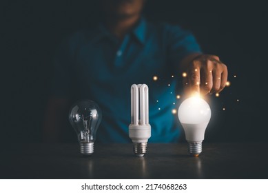 Energy saving concept, Fluorescent bulb, incandescent lamp and LED bulb, Human hand touch for select LED light bulb for best power saving, Electricity conservation.
