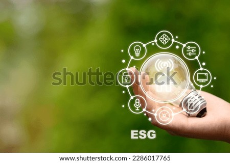 energy saving and environmental conservation icon concept in hand-held bulbs for environmental, social and governance in sustainable business and reducing global warming