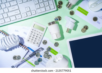 Energy saving with modern modernization technology and devices. Electricity bills, LED bulbs, heat thermostat, calculator on light green table copy space. Go green, energy costs concept - Shutterstock ID 2135779051
