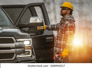 Energy Sector Worker In The Field. Electrical Infrastructure Construction Technician And His Company Truck. High Voltage Lines Maintenance.